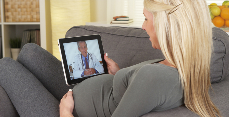 Doctor speaking with a pregnant patient through a virtual visit on a tablet