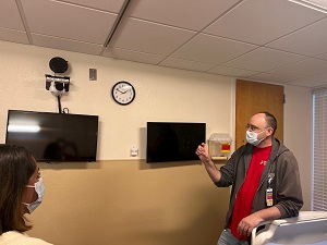 Jason Zibart, the hospital’s Community Connected Health Manager, points out the VitalChat system in one of the hospital’s patient rooms that helps nurses monitor patients.