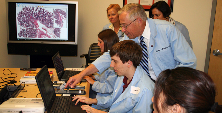 Dr. Ronald S. Weinstein works with a group of students