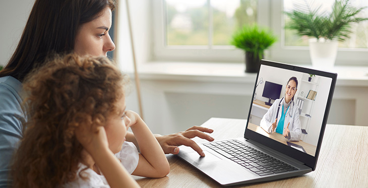 Image of woman and child engaging in telehealth via laptop computer.